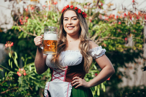 Баварская женщина празднует Октоберфест пивом

