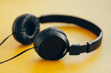 Sarı arka planda siyah kulaklıklar. Müzik konsepti