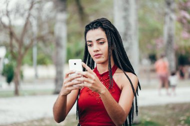 Parkta telefon kullanan güzel afro Amerikalı kadın. İletişim kavramı.