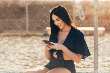 Sokakta cep telefonunu kullanan güzel bir genç kadının portresi..