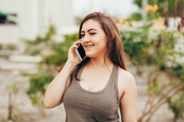 Sokakta cep telefonunu kullanan güzel bir genç kadının portresi..