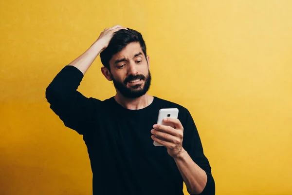 Šokovaný Vousatý Muž Pomocí Mobilního Telefonu Žlutém Pozadí — Stock fotografie