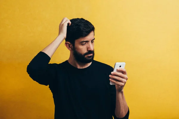 Choqué Homme Barbu Aide Téléphone Mobile Sur Fond Jaune — Photo