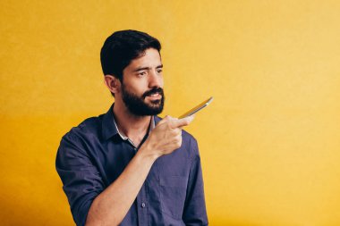 Eğlence, teknoloji, iletişim ve insan kavramı - kaydedici komutunu kullanarak veya Smartphone'da çağırarak genç adam