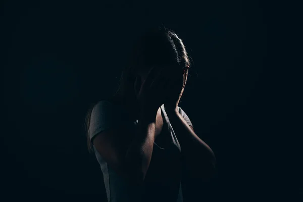Sad woman in dark room. Depression and anxiety disorder concept