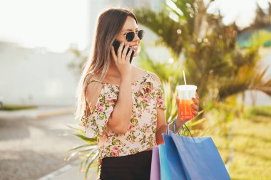 Bir akıllı telefon ile alışveriş ve çantaları taşırken alışveriş kadın el