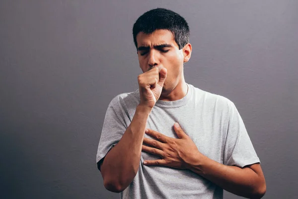 Gri bir arka plan üzerinde izole yumruğunu içine öksürük adam