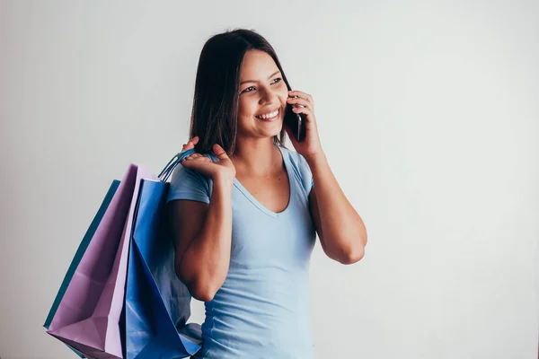 携帯電話の女性の使用とショッピングバッグを保持 — ストック写真