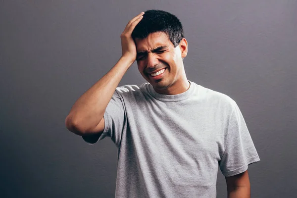 Портрет роздратованого чоловіка середнього віку, який страждає від головного болю, ізольованого на сірому фоні — стокове фото