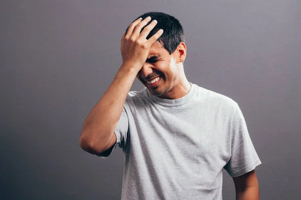 Retrato de un hombre molesto de mediana edad que sufre de un dolor de cabeza aislado sobre un fondo gris — Foto de Stock