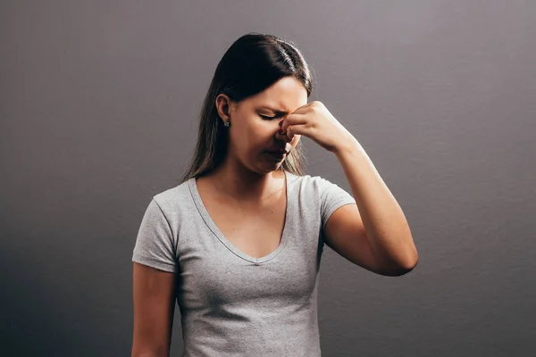 Синусовий біль, тиск синуса, синусит. Сумна жінка тримає ніс і голову, тому що біль у пазусі — стокове фото