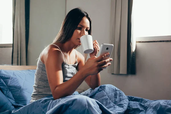 Wanita Duduk Tempat Tidur Menggunakan Ponsel Dan Sarapan — Stok Foto