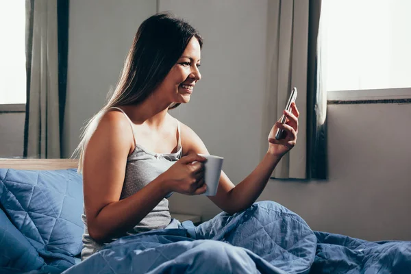 Wanita Duduk Tempat Tidur Menggunakan Ponsel Dan Sarapan — Stok Foto