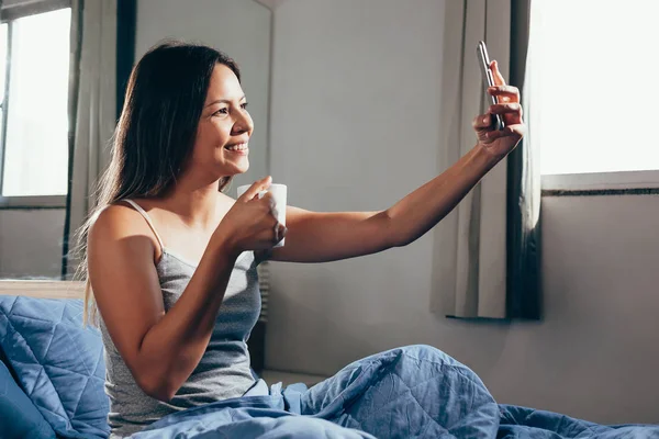 Wanita Duduk Tempat Tidur Menggunakan Ponsel Dan Sarapan — Stok Foto