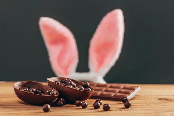 Osterkonzept Hasenohren Hinter Schokoladen Osterei Auf Holztisch — Stockfoto