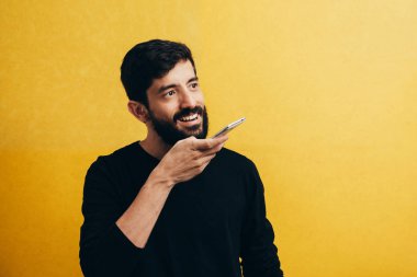 Eğlence, teknoloji, iletişim ve insan kavramı - kaydedici komutunu kullanarak veya Smartphone'da çağırarak genç adam