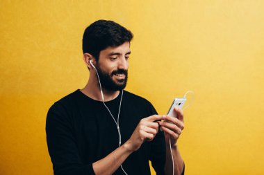 Adam cep telefonunu kulaklık ile müzik dinleme