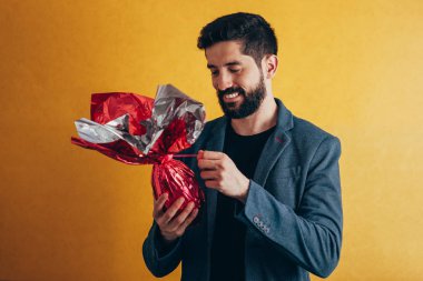 Mutlu paskalyalar. Mutlu adam tutarak çikolata Paskalya yortusu yumurta