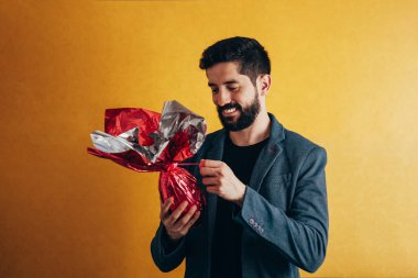 Mutlu paskalyalar. Mutlu adam tutarak çikolata Paskalya yortusu yumurta