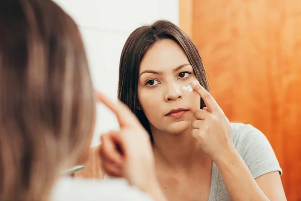Hudvård Kvinna Applicera Hudkrämen Hennes Ansikte Framför Spegeln — Stockfoto