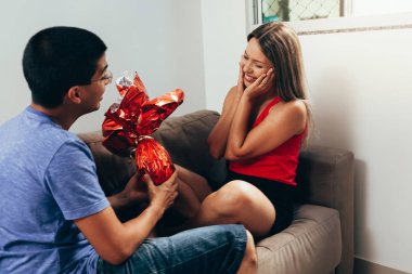 Erkek arkadaşı bir çikolata Paskalya yumurta ile sunar.