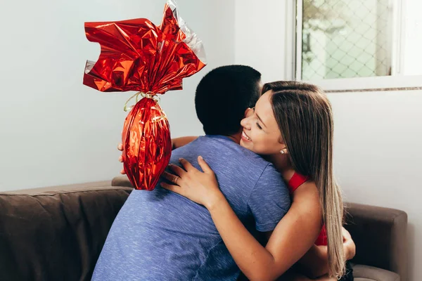 Boyfriend presents his girlfriend with a chocolate easter egg