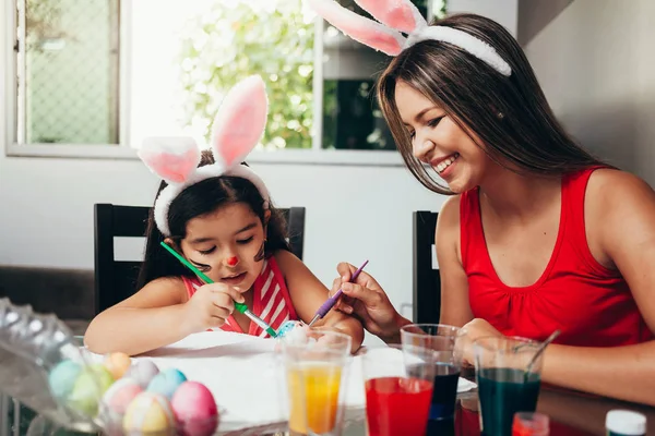Happy easter! A mother and her daughter painting Easter eggs. Ha — Stock Photo, Image