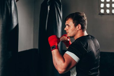 Spor salonunda kum torbası eğitim savaşçı adam