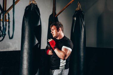 Spor salonunda kum torbası eğitim savaşçı adam