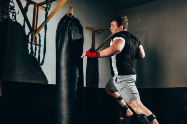 Spor salonunda kum torbası eğitim savaşçı adam