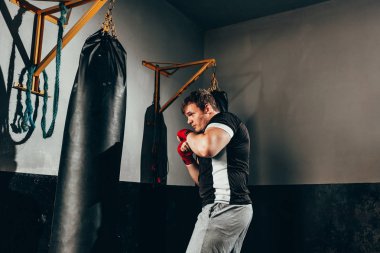 Spor salonunda kum torbası eğitim savaşçı adam