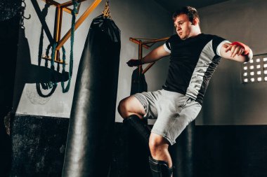 Spor salonunda kum torbası eğitim savaşçı adam