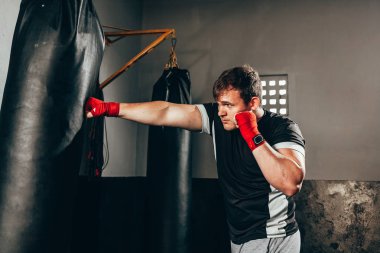 Spor salonunda kum torbası eğitim savaşçı adam