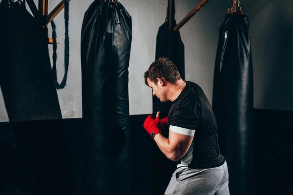 Vechter man opleiding in zware tas op sportschool — Stockfoto