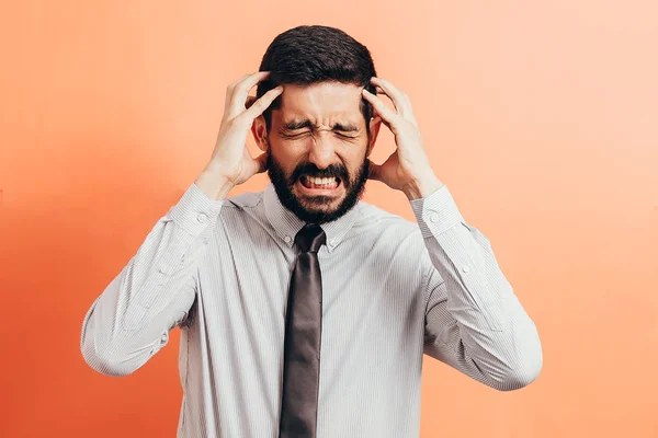 Portrait of an annoyed businessman suffering from a headache isolated on color background — Stock Photo, Image