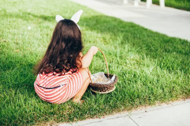 Tavşan kulakları ve Paskalya yumurtaları Bahçe sepeti ile sevimli küçük kız. Paskalya yumurtası avı