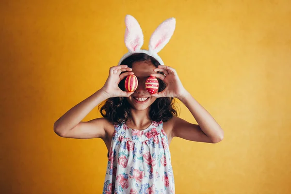 Uma menina feliz mostrando ovos de páscoa decorados — Fotografia de Stock
