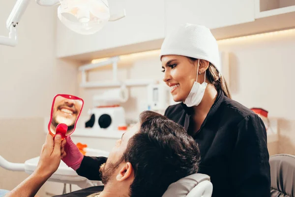 Dokter gigi wanita dengan pasien pria di klinik — Stok Foto