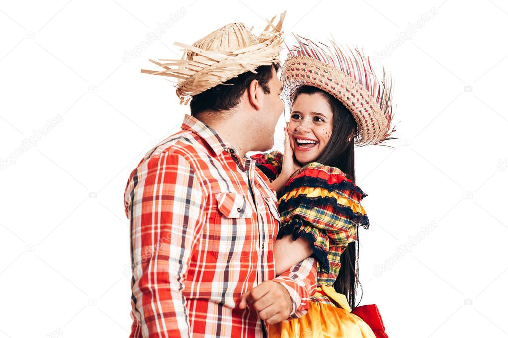 Brazilian couple wearing traditional clothes for Festa Junina - June festival - dancing isolated on white background