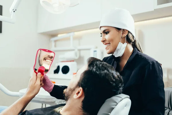 Dentista femenina con paciente masculino en la clínica — Foto de Stock