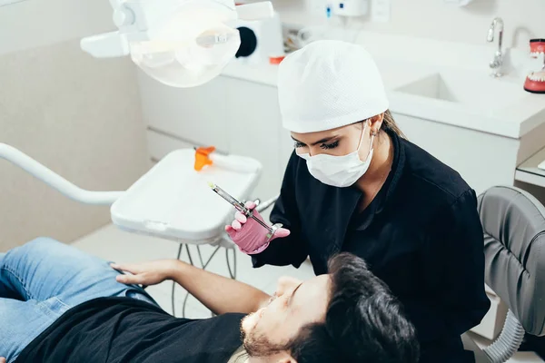 Dentista femenina con paciente masculino en la clínica — Foto de Stock