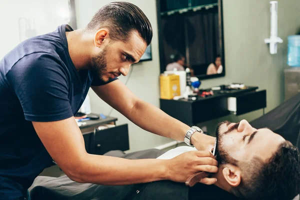 Cliente durante a barba e o cabeleireiro na barbearia — Fotografia de Stock