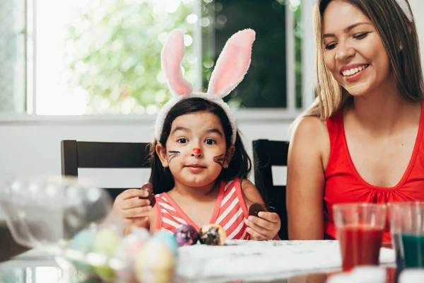 Happy easter! A mother and her daughter painting Easter eggs. Happy family preparing for Easter. Cute little child girl wearing bunny ears on Easter day — Stock Photo, Image