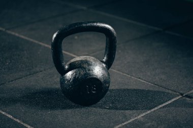 Gri zemin üzerine siyah ağır kettlebell halter