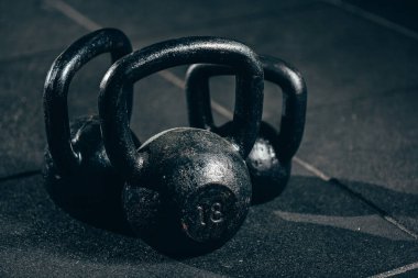Gri zeminde siyah ağır kettlebells, halter