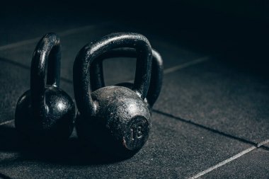 Gri zeminde siyah ağır kettlebells, halter