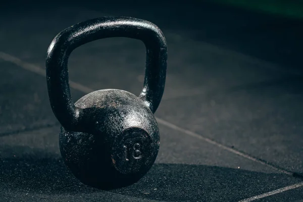 Black heavy kettlebell on gray floor, weightlifting — Stock Photo, Image