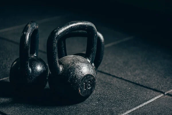 Gri zeminde siyah ağır kettlebells, halter