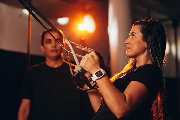 Jovem mulher fitness treinamento com tiras de fitness trx — Fotografia de Stock