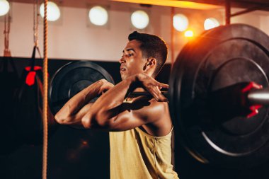 Spor salonunda ağır egzersizler yapan kaslı adam. Sağlık kulübünde halter yapan genç adam